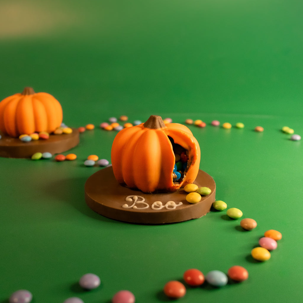 Mini chocolate smash pumpkins, one broken open showing Smarties