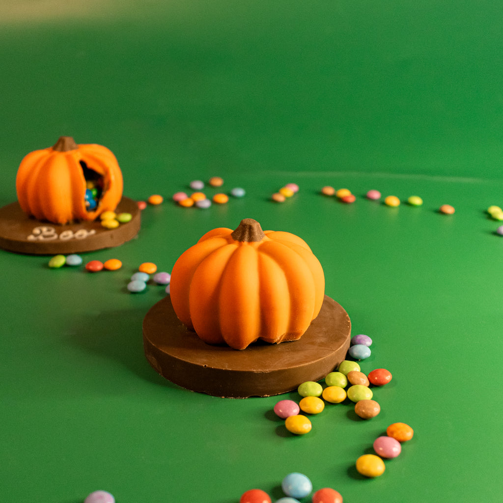 Mini orange chocolate pumpkins on chocolate plaques with Smarties